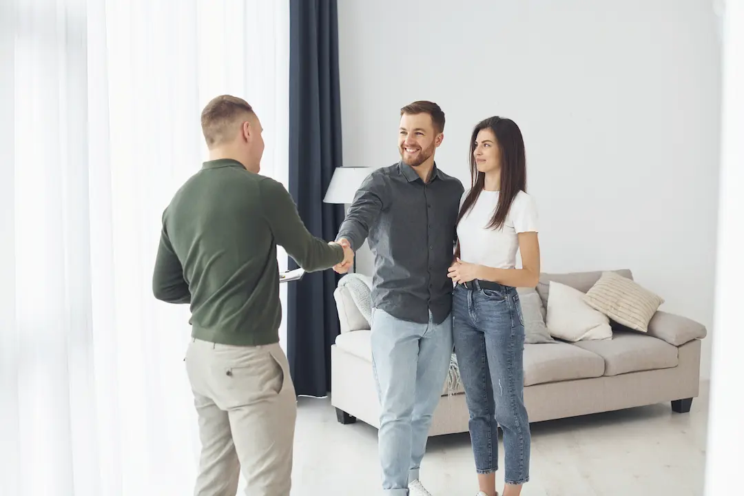 Salesman helps young couple in choosing an apartment to rent